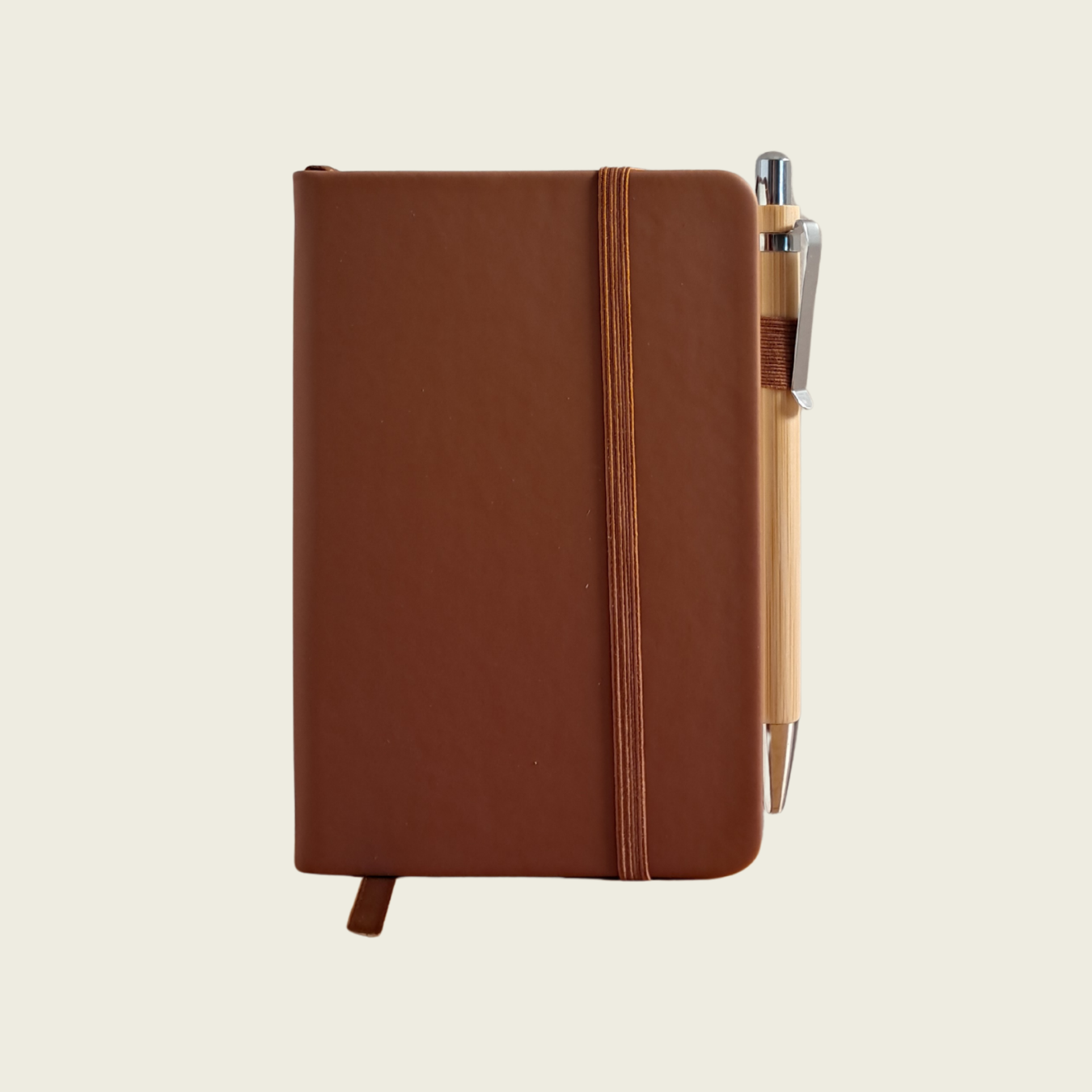 Brown notebook with a pen on a beige background