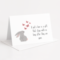 Greeting card with a rabbit illustration and butterfly graphics on a white background