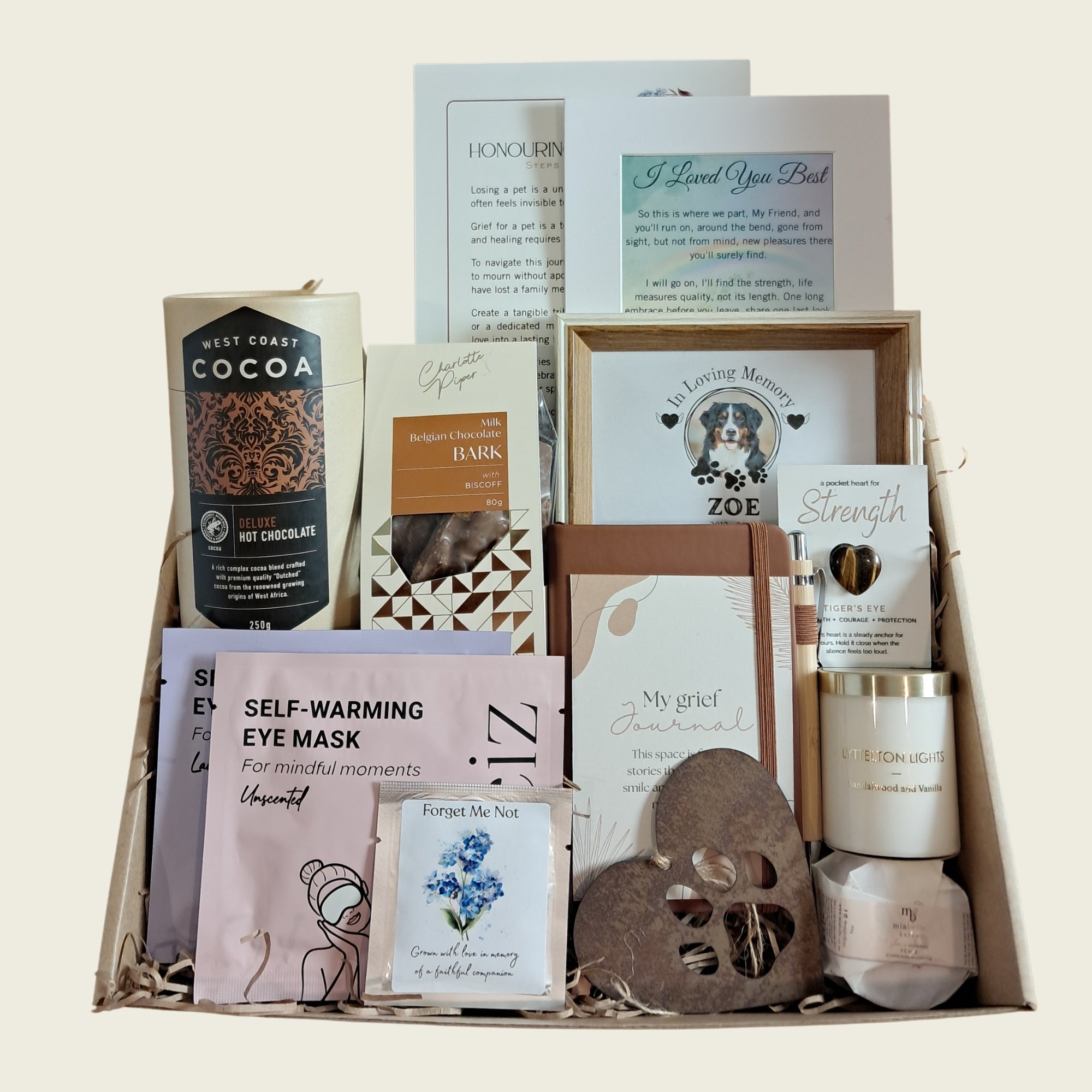 Premium pet loss sympathy gift box from Rainbow Bridge Comfort. The curated gift set includes a personalised dog remembrance photo frame, a grief journal, a scented candle, self-warming eye masks, artisan hot chocolate, and comforting keepsakes, beautifully presented in a gift box.
