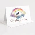 A white greeting card standing upright on a matching envelope against a light gray background. The card features a watercolor rainbow in pastel colors with a black cat silhouette sitting in the center, above the cursive text 'Sorry for your loss'.