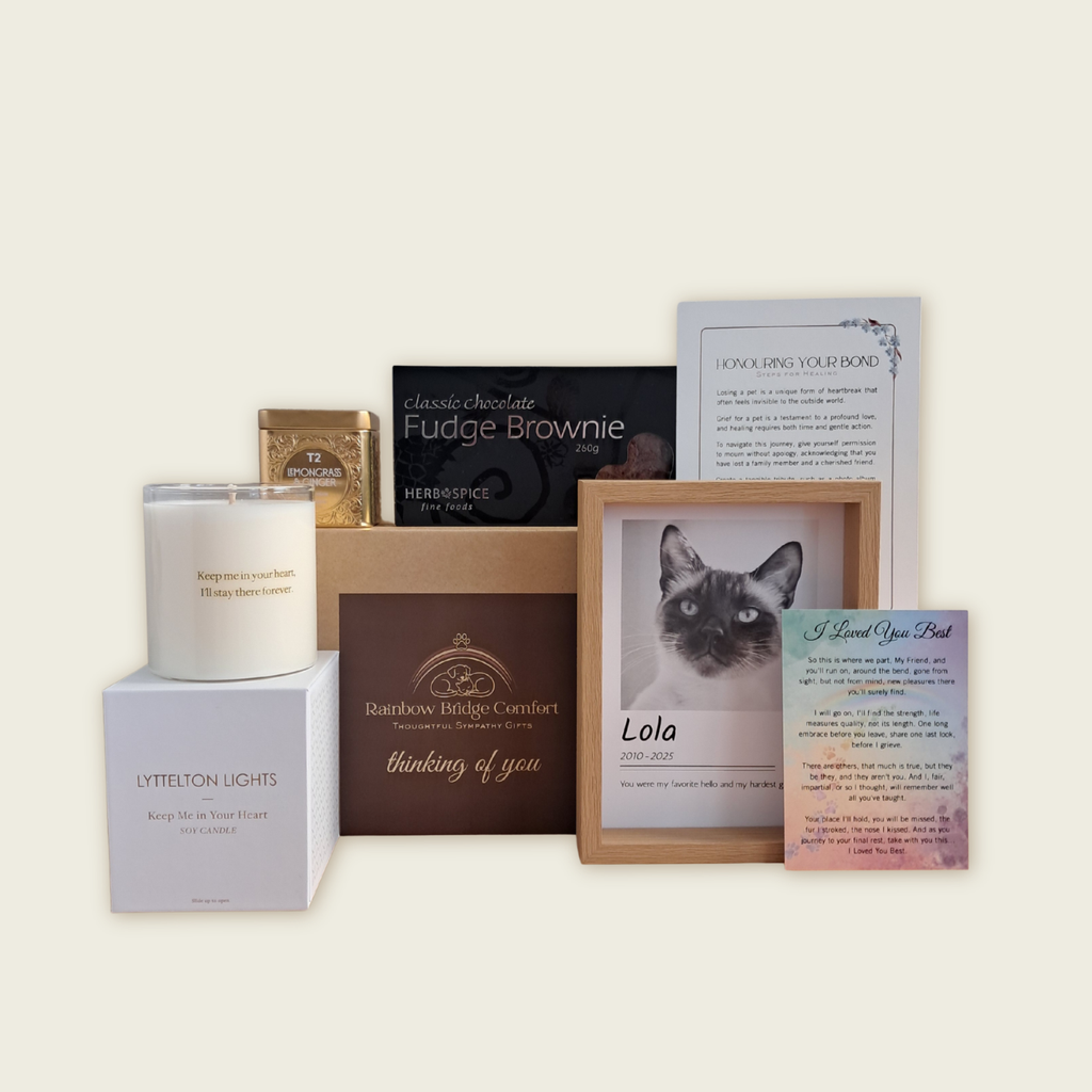 The Remembrance Deluxe pet sympathy kit: includes a personalized framed photo, a memorial candle, tribute poem, and gourmet treats arranged in a gift box.