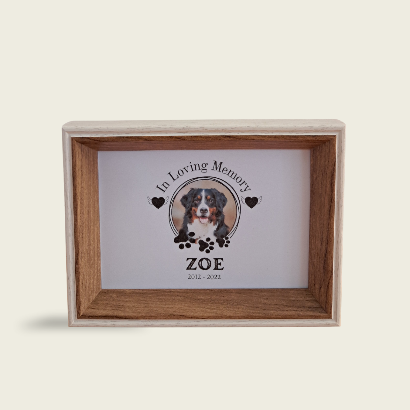 Memorial box for a pet and wooden frame on a beige background