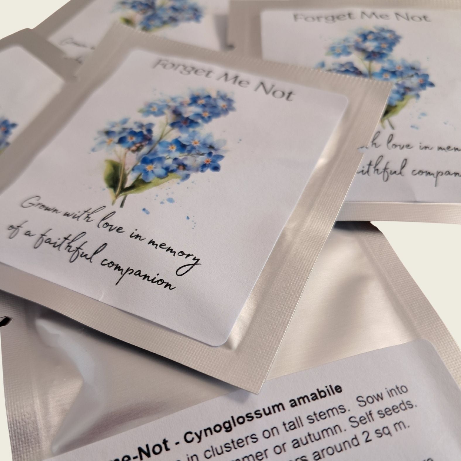 Packets of 'Forget Me Not' seeds with floral design and text on a neutral background