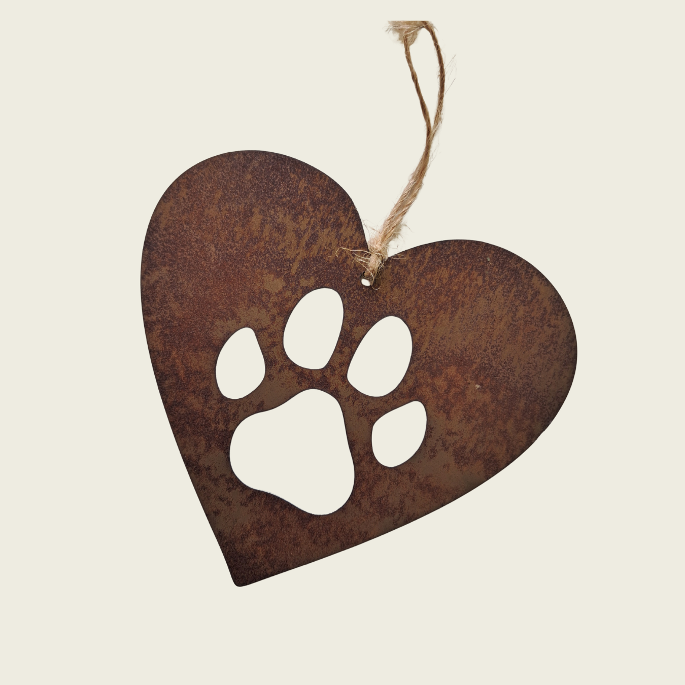 Heart-shaped metal ornament with a white paw print cutout on a beige background