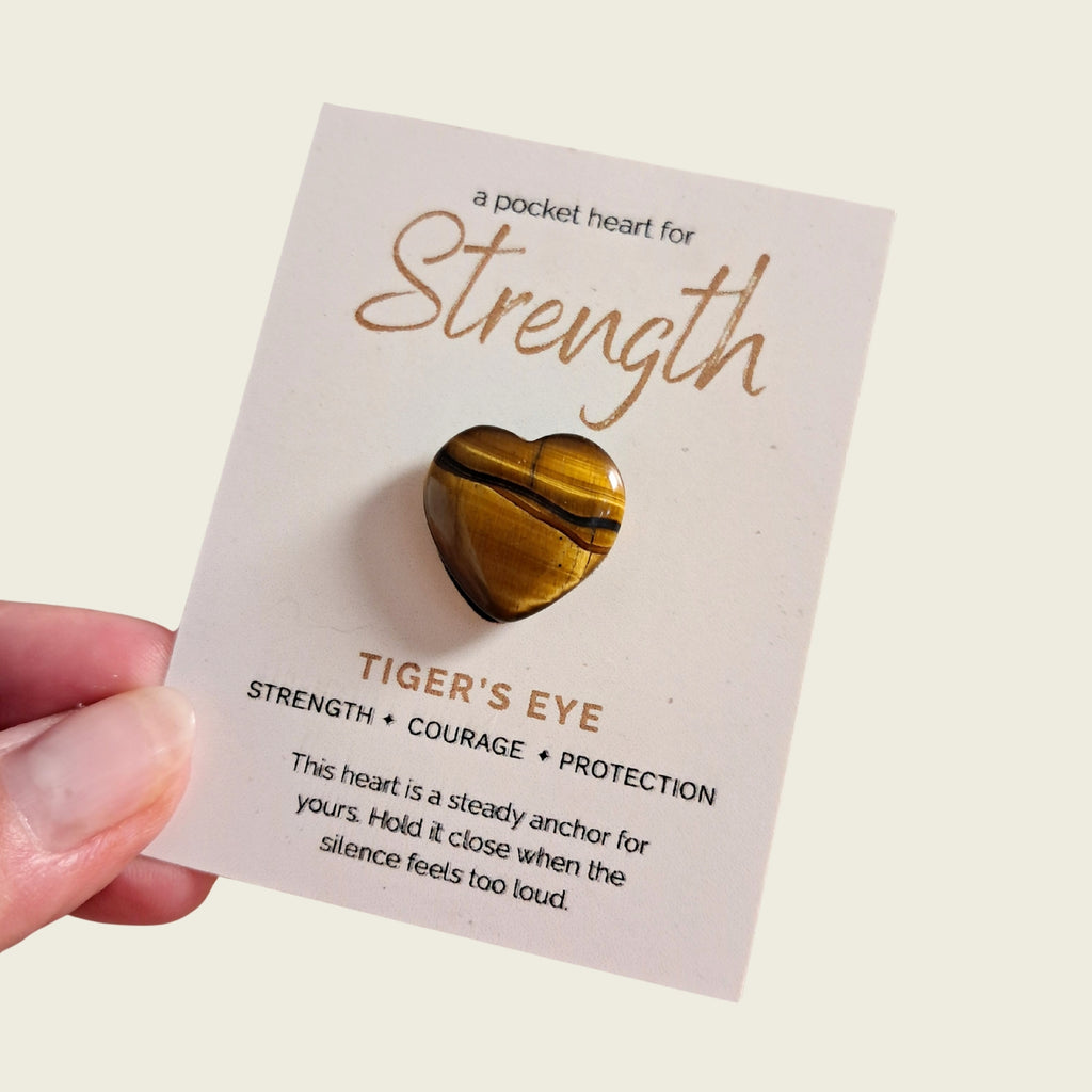 A Tiger's Eye heart-shaped pocket stone attached to a display card that reads "A pocket heart for Strength, courage, and protection" from the Rainbow Bridge Comfort pet sympathy gift box.